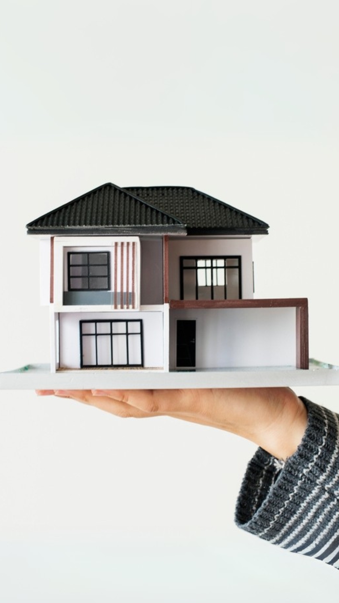 Estate agent holding model house in their hand Estate agent holding model house in their hand